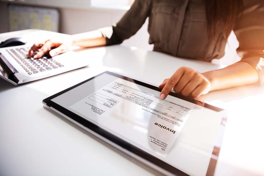 女商人在她的标签和笔记本电脑上工作的发票。
